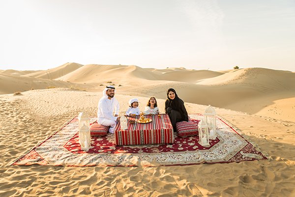 Arabian family in the desert Arabian family with kids having fun in the desert - Parents and children celebrating holiday in the Dubai desrt